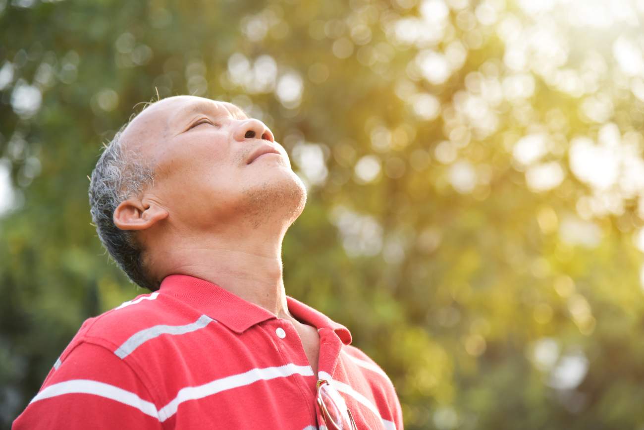 Senior man breathing in outside air