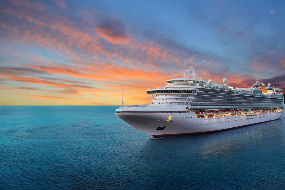 Picture shows a cruise ship in front of a setting sun